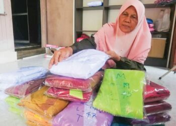 CHE Melah Hassan menunjukkan sebahagian koleksi telekung yang dijahitnya di Felda Bukit Bading, Ajil, Hulu Terengganu, semalam.
– UTUSAN/NOOR HAYATI MAMAT