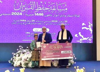 NUR Muhammad Al-Akhyar Noor Azam (kiri) menerima hadiah daripada Mohamad Wadi Annuar Ayub setelah muncul juara pertandingan Musabaqah Hafazan al-Quran Piala Ustaz Wadi Annuar 2024 di Akademi Darul Ilmi, Sungai Petani.