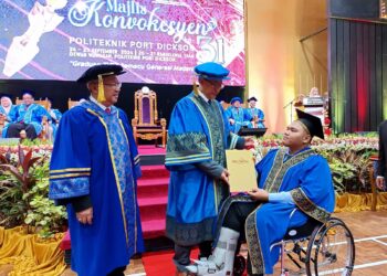 IR. Dr. Ahmad Sabirin Arshad (tengah) menyampaikan sijil diploma kepada Muhammad Farhad yang berkerusi roda pada Majlis Konvokesyen Politeknik Port Dickson Kali ke-31 Tahun 2024, Port Dickson semalam. – UTUSAN/NOR AINNA HAMZAH