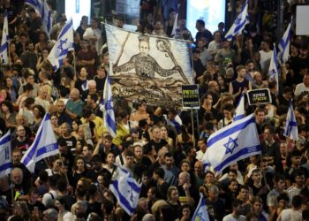 PENUNJUK perasaan mengangkat bendera dan sepanduk semasa demonstrasi antikerajaan kelmarin, bagi mendesak pembebasan tebusan Israel di Gaza.- AFP