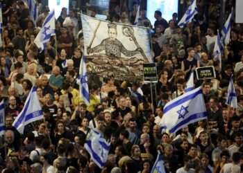 PENUNJUK perasaan mengangkat bendera dan sepanduk semasa demonstrasi antikerajaan kelmarin, bagi mendesak pembebasan tebusan Israel di Gaza.- AFP