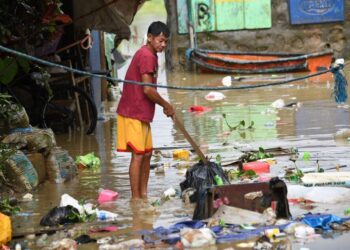 PENDUDUK mengalihkan sampah yang dihanyutkan oleh banjir berikutan hujan lebat yang tercetus daripada taufan Yagi di bandar Cainta, timur Manila pada 3 September lepas.- AFP