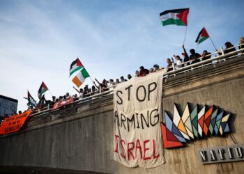 PENUNJUK perasaan mengibarkan bendera Palestin dan memegang sepanduk semasa demonstrasi pro-Palestin di Jambatan Waterloo, di London pada 11 Mei lalu.- AFP