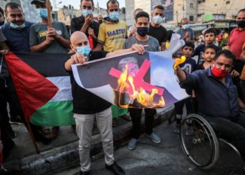 PENUNJUK perasaan Palestin membakar potret Donald Trump semasa protes perjanjian normalisasi Israel dengan UAE dan Bahrain di Khan Younis, selatan Gaza pada 23 September 2020.- AFP