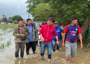 AHMAD Nazrin Abdul Aziz (baju merah) bersama ahli jawatankuasa Pemuda UMNO Bahagian Arau meninjau dan menyampaikan bantuan kepada mangsa banjir di sekitar Arau, Perlis hari ini.-UTUSAN