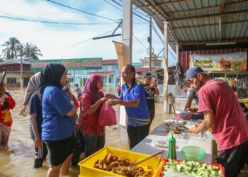 JAMALUDIN Ahmad (tengah) atau lebih dikenali sebagai Pak Din One Dollar mengedarkan makanan percuma kepada mangsa banjir di Kampung Suka Menanti, Alor Setar. - UTUSAN/ SHAHIR NOORDIN