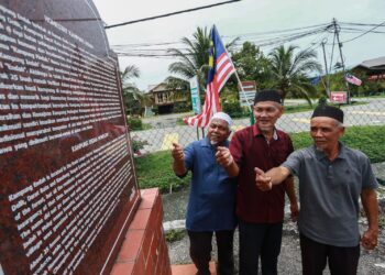 ZULHAMIN Mohd. Rus bersama penduduk Shaffei Mohamad dan Salimin Salleh menunjukkan tugu pelancongan Kampung Endah yang menyimpan peristiwa hitam kekejaman komunis, dekat Morib di Kuala Langat, Selangor. – UTUSAN/AFIQ RAZALI