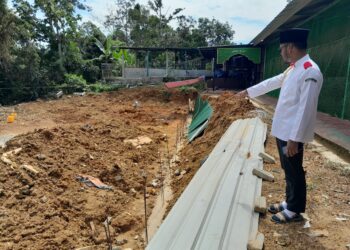 MUHAMMAD ASHRAFF Md. Khaire menunjukkan tembok penghalang hakisan tanah yang dibina, namun terhenti kerana kekurangan dana.