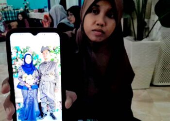 NURSHARINA Mohd. Zen menunjukkan gambar kenangan majlis persandingan dengan suaminya dua tahun lalu.