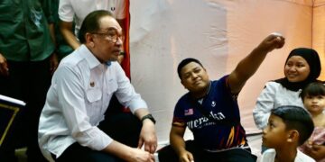 ANWAR Ibrahim bertanya khabar mangsa banjir yang berlindung sementara di PPS SMK Agama Kedah ketika mengadakan lawatan mengejut ke negeri ini di Alor Setar. - UTUSAN/SHAHIR NOORDIN