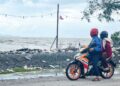 Ppenunggang motosikal melihat sampah yang dihanyut di pesisiran pantai berikutan fenomena air pasang di Kuala Perlis semalam. – UTUSAN/MOHD. HAFIZ ABD. MUTALIB