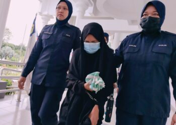 TERTUDUH diiringi polis ketika dihadapkan ke Mahkamah Majistret Alor Gajah, Melaka.