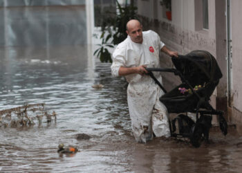 SEORANG lelaki meredah banjir sambil mengangkut barang di Slobozia Conachi, di Galati, Romania, kelmarin.- AGENSI