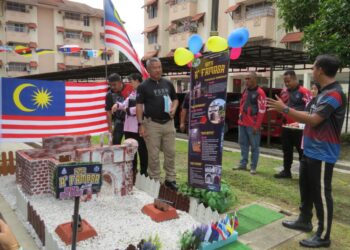 SIK Choon Foo (tiga dari kiri) mengadili replika bangunan bersejarah di Ibu Pejabat Polis Daerah (IPD) Gua Musang sempena Sambutan Hari Malaysia di Gua Musang semalam. – UTUSAN/AIMUNI TUAN LAH