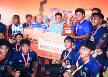 AB. RAUF Yusoh meraikan pasukan SSTMI yang muncul juara Melaka International Rugby 10s kategori lelaki terbuka anjuran Bank Muamalat 
di Stadium Hang Tuah, Melaka. - UTUSAN/AMRAN MULUP