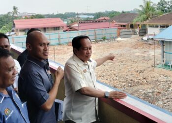 AHMAD Maslan (kanan) meninjau kerja pembinaan semula bangunan daif di SK Kampung Melayu, Kluang.