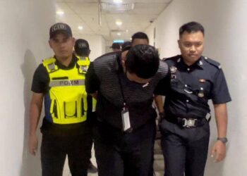 MOHD. Hamdi Hanafi (tengah) yang berdepan empat tuduhan melakukan amang seksual fizikal terhadap murid lelakinya dibawa keluar dari Mahkamah Sesyen Kuaka Terengganu, hari ini. - UTUSAN/TENGKU DANISH BAHRI TENGKU YUSOFF