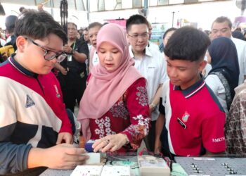 FADHLINA Sidek (tengah) melihat demonstrasi oleh para pelajar berkaitan kerja-kerja pendawaian elektrik Majlis Pelancaran Hari TVET Sekolah Peringkat Kebangsaan di Dewan SMK Seri Perdana, Kluang.