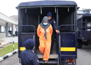 TERTUDUH (tengah) semasa diiring polis untuk prosiding reman di Mahkamah Kota Bharu, Kelantan hari ini-UTUSAN/KAMARUL BISMI KAMARUZAMAN.