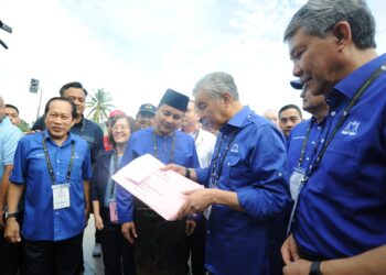 AHMAD ZAHID Hamidi melihat borang pencalonan Syed Hussien Syed Abdullah di pusat penamaan calon PRK DUN Mahkota di Dewan Tunku Ibrahim Ismail, Kluang.