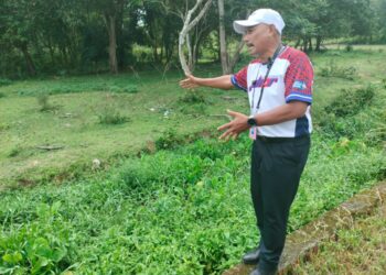 MOHAMAD HAIZAN Jaafar menunjukkan tali air di Kampung Bentong Dalam yang tidak diselenggara dan boleh menyebabkan banjir jika berlaku hujan lebat.