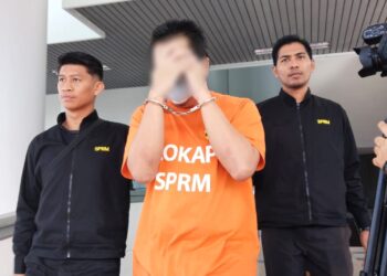 SUSPEK diiringi pegawai SPRM dibawa ke Mahkamah Majistret, Ayer Keroh, Melaka untuk permohonan reman. - UTUSAN/MUHAMMAD SHAHIZAM TAZALI