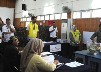 RAMLAN Harun (dua dari kiri) meninjau proses pengundian awal PRK DUN Mahkota di Kem Mahkota, Kluang.