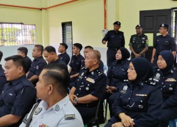 M. KUMAR (berdiri, tengah) menyaksikan proses pengundian awal di Dewan Pengaman Zamrud di IPD Kluang.