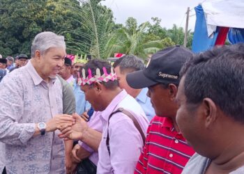 AHMAD ZAHID Hamidi bersalaman dengan masyarakat Orang Asli pada Majlis Tautàn Kasih di Kampung Orang Asli Tanah Runtuh, Kluang.