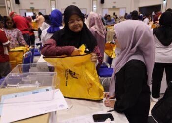 PETUGAS SPR melakukan semakan dan pemeriksaan ke atas kertas undi di Dewan Tunku Ibrahim Ismail, Kluang.