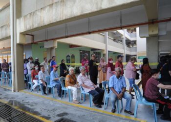 PARA pengundi warga emas duduk berbaris sebelum memasuki pusat pengundian  di SMK Seri Perdana, Kluang.