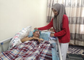 SARAH Najihah Ramlee memberikan susu khas kepada bapanya yang terlantar akibat serangan angin ahmar ketika ditemui di Flat Cempakapuri, Nilai, Seremban.-UTUSAN/NUR SHARIEZA ISMAIL