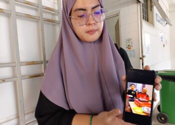 FARHANA Omar menunjukkan gambar Allahyarham bapa mentuanya ketika ditemui pemberita di Unit Perubatan Forensik, Hospital Tuanku Ampuan Najihah (HTAN), Kuala Pilah hari ini.-UTUSAN/NOR AINNA HAMZAH.