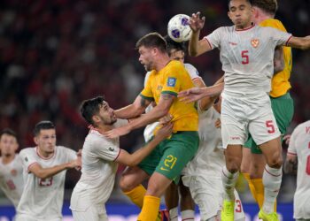 PEMAIN Australia Cameron Burgess (tengah) cuba menandukkan bola di utara dengan dicabar pertahanan Indonesia dalam aksi Kelayakan Pusingan Ketiga Piala Dunia 2026 di Stadium Gelora Bung Karno.-AFP