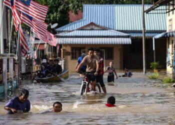 PENDUDUK bermain air banjir di Kampung Suka Menanti di Alor Setar, Kedah. - UTUSAN/ SHAHIR NOORDIN