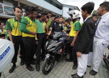 AZIZI Mat Aris (tengah) bersama pelajar semasa program advokasi kesedaran keselamatan jalan raya  di SMK Dato' Haji Mohd Taib dekat Ipoh, Perak hari ini. - UTUSAN