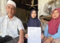 WAN Nur’alyaa Syaza Awang (tengah) bersama ibu bapanya menunjukkan slip tawaran pengajian USM yang diterimanya tetapi masalah kewangan menjadi kekangan kepadanya di Tok Bali, Pasir Puteh, Kelantan, baru-baru ini. – UTUSAN/TOREK SULONG