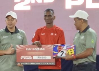 TAKIYUDDIN Hassan (kiri) menyampaikan hadiah kepada salah seorang pemenang acara larian Kota Bharu Half Maraton (KBHM) di Dewan Jubli Perak Majlis Perbandaran Kota Bharu-Bandar Raya Islam (MPKB-BRI), Kota Bharu, Kelantan, hari ini. - UTUSAN/YATIMIN ABDULLAH