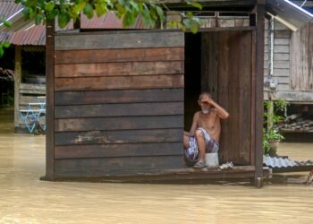 Warga emas, Ahmad Din, 85, melihat sesuatu sementara menunggu bantuan tiba ketika banjir melanda Kampung Sungai Kechil, Nibong Tebal petang semalam. UTUSAN/IQBAL HAMDAN