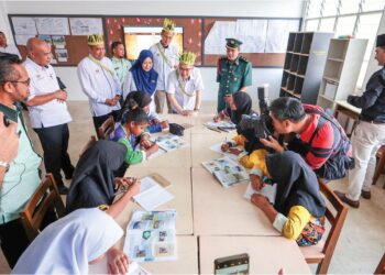 WONG Kah Woh (tengah)  menyantuni murid-murid SK RPS Banun semasa mengadakan lawatan kerja 
ke sekolah berkenaan dekat Gerik, Perak semalam. – UTUSAN/FADZIL ZAINOL