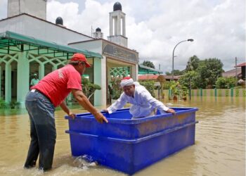 Warga emas menggunakan tong sebagai sampan mengharung air banjir di Masjid Tuan Hussin, Titi Gajah bagi menunaikan Solat Jumaat. UTUSAN/ SHAHIR NOORDIN