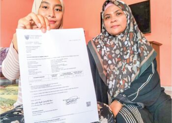 NUR Fatihah Mohammad menunjukkan surat tawaran ke Universiti Malaya di samping ibu angkatnya, Nik Siti Rohaizan Nik Hashim di Kampung Pelain, Batu Gajah, Tanah Merah, Kelantan. – UTUSAN/ROHANA ISMAIL