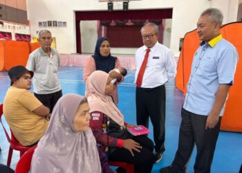 PENGERUSI Jawatankuasa Kesihatan Perlis, Megat Hashirat Hassan (dua dari kanan) berbual bersama Asmini Hashim (berdiri, tiga dari kanan) yang dipindahkan ke Pusat Pemindahan Sementara (PPS) Sekolah Kebangsaan (SK) Arau. -UTUSAN/ASYRAF MUHAMMAD