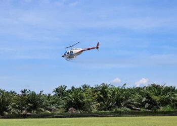 HELIKOPTER melakukan demonstrasi semburan racun perosak biologi menggunakan bakteria ‘Bacillus thuringiensis’  di ladang sawit di Kampung Banjar, Ayer Tawar semalam.