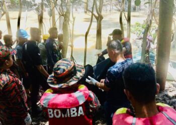 PASUKAN bomba mengangkat mayat nelayan  yang maut disambar buaya di Sungai Latangan, Kinabatangan, semalam. - IHSAN BOMBA