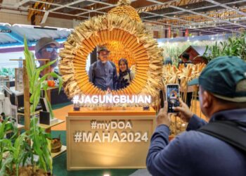 Seorang pengunjung  mengambil gambar dekorasi berkonsepkan jagung di reruai Jabatan Pertanian sempena Pameran Pertanian. 
– Utusan/AMIR KHALID