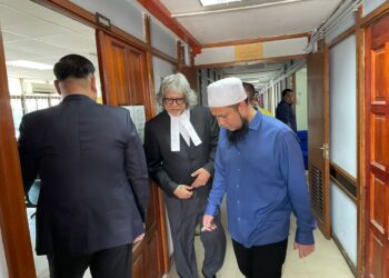 EBIT Lew bersama Ram Singh (tengah) semasa hadir perbicaraan kes gangguan seksual di Mahkamah Majisret Tenom semalam.