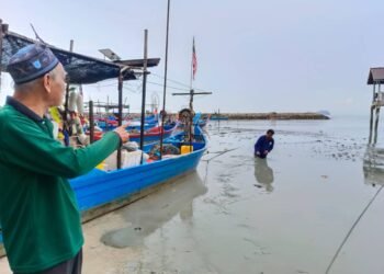 ZAKARIA (kiri) menunjukkan kawasan berselut tebal yang menganggu sumber pendapatan nelayan di Sungai Batu, Teluk Kumbar, Pulau Pinang  sejak Ogos lalu.