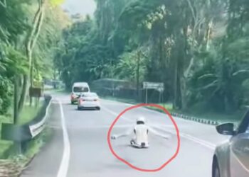 TANGKAP layar satu rakaman video menunjukkan seorang individu yang lengkap berpakaian khas (dalam bulatan merah) mendepakan tangannya ketika sedang meluncur dalam keadaan duduk di sebatang jalan raya di Jalan Tun Sardon, Balik Pulau, Pulau Pinang