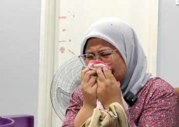 NURUL FATEHA Md. Sandollah mencium baju terakhir dipakai Haura Najia Mohd. Kamaruddin Helsa ketika ditemui di Taman Bertam Impian, Melaka. - UTUSAN/HADI AB. MANAP